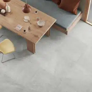 Image of living room with a coffee table and chair. the image highlights the Ashlee’s Curton stone floor tiles.