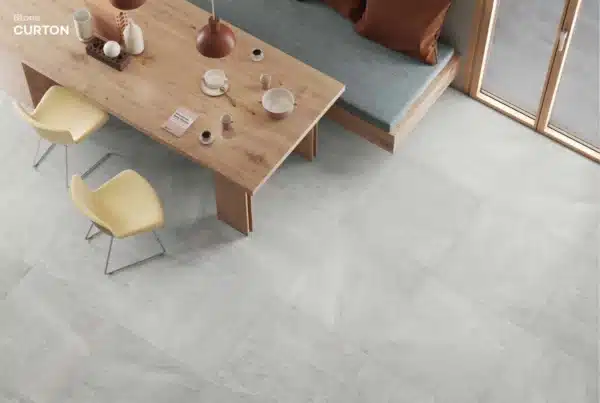 Image of living room with a coffee table and chair. the image highlights the Ashlee’s Curton stone floor tiles.